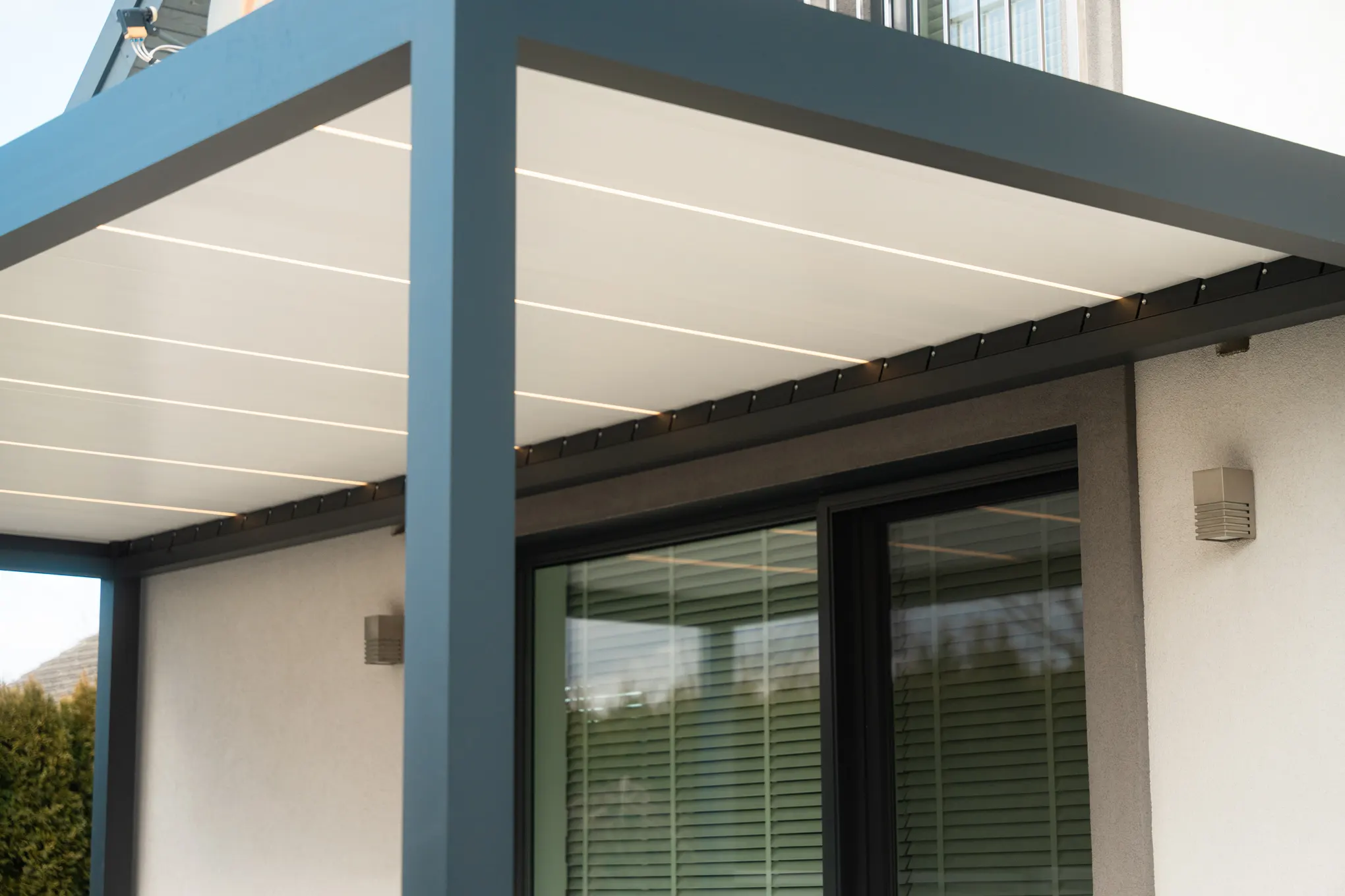 Pergola bioklimatyczna Aura z otwartymi lamelami nad tarasem